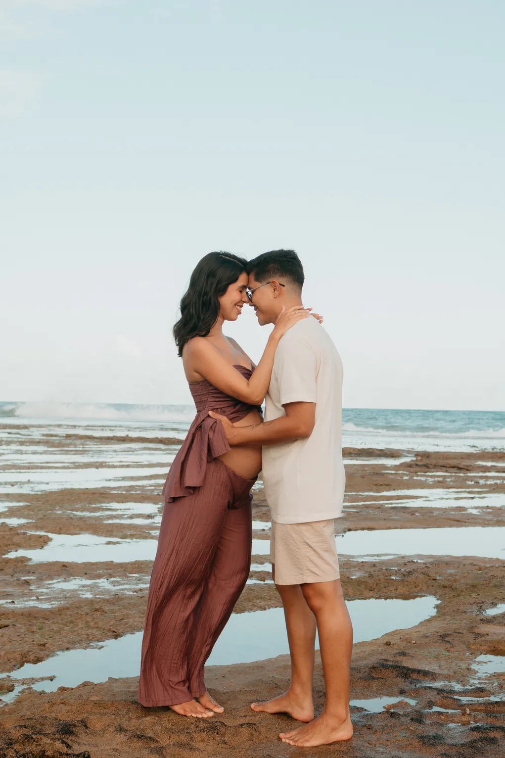 Casal se beijando entre as poças de maré